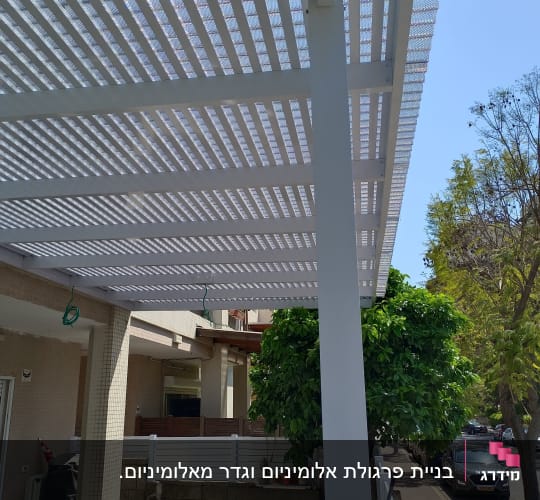 פרגולה מאלומיניום עם קורות לבנות בחצר